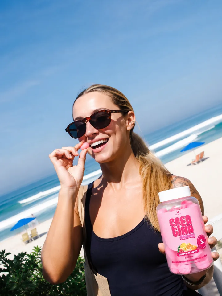 Creator na praia colocando uma goma de Crea Gummy na boca